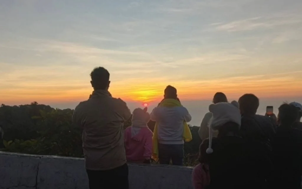 Visitors watch the sunrise from a viewpoint at Doi Inthanon.