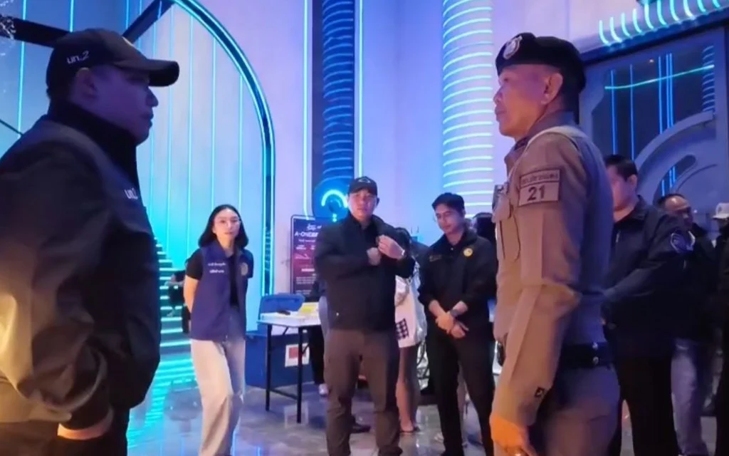 Police officers and staff gather inside a brightly lit entertainment venue.