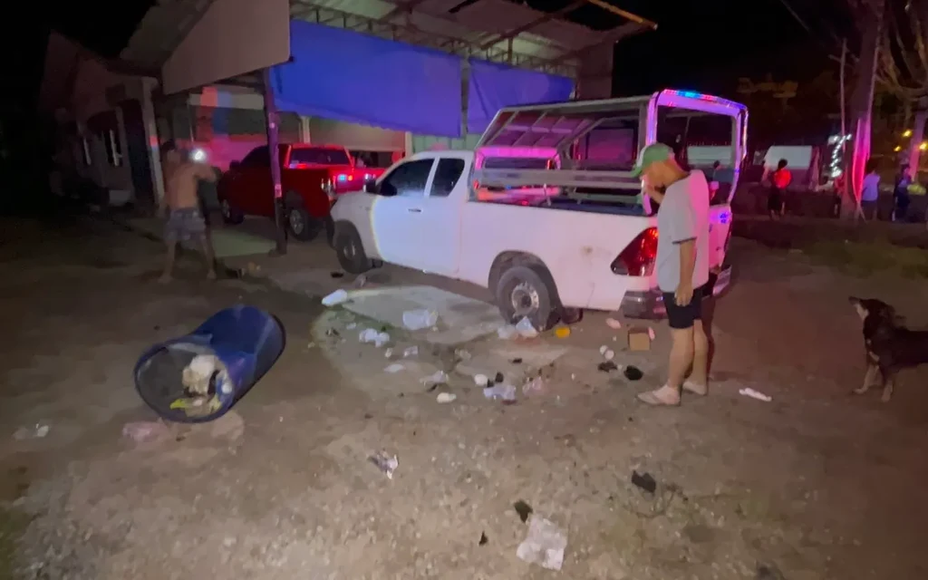 Night scene of a vehicle accident with people standing nearby.