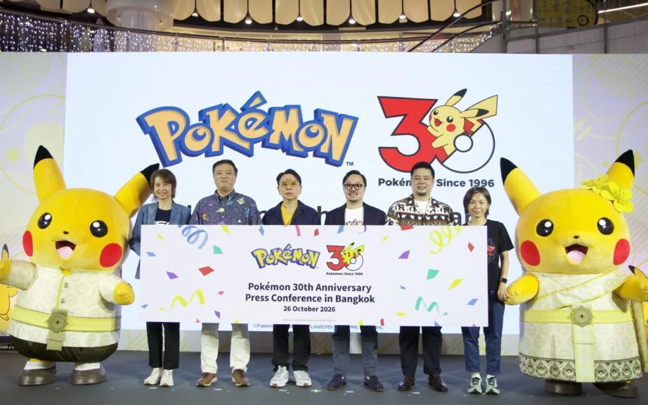 People pose with Pokémon characters at a 30th anniversary press conference.