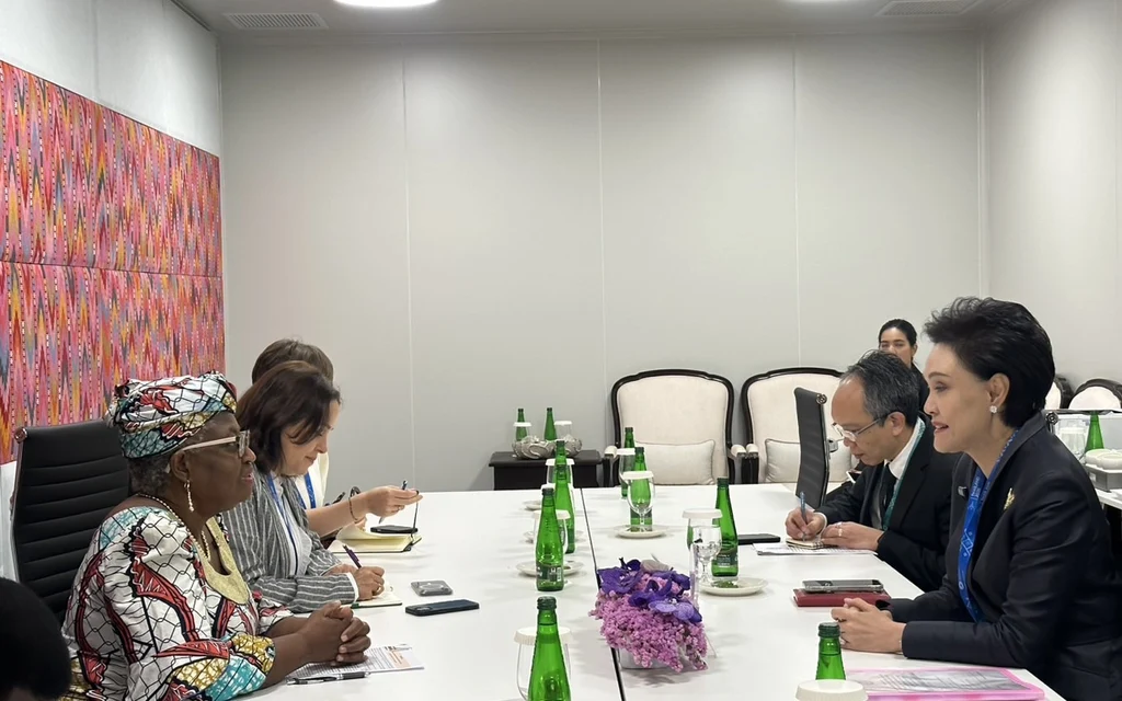 Officials meet around a conference table during international meetings.