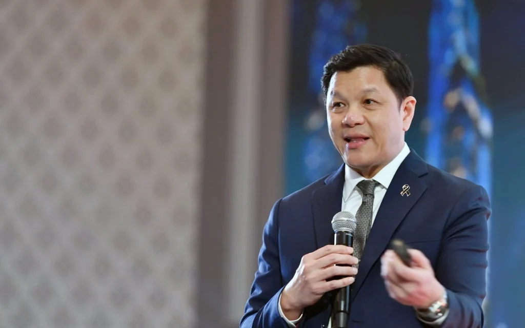 A man in a suit speaking into a microphone.