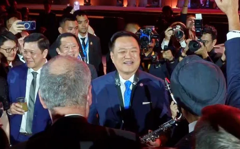 Anutin surrounded by guests and photographers at a reception