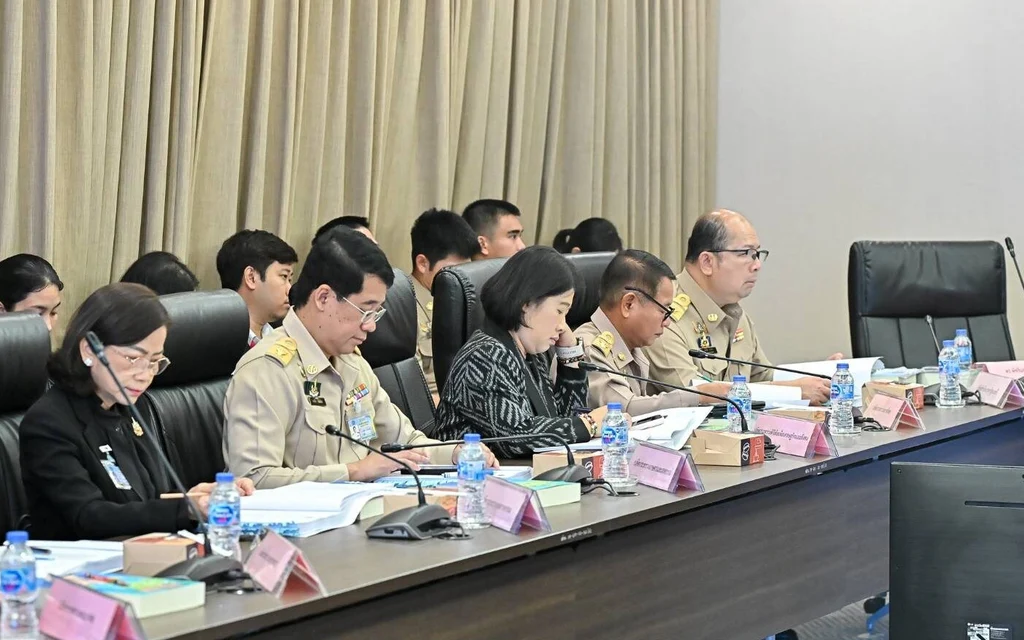 Officials attend a consumer protection board meeting around a conference table.