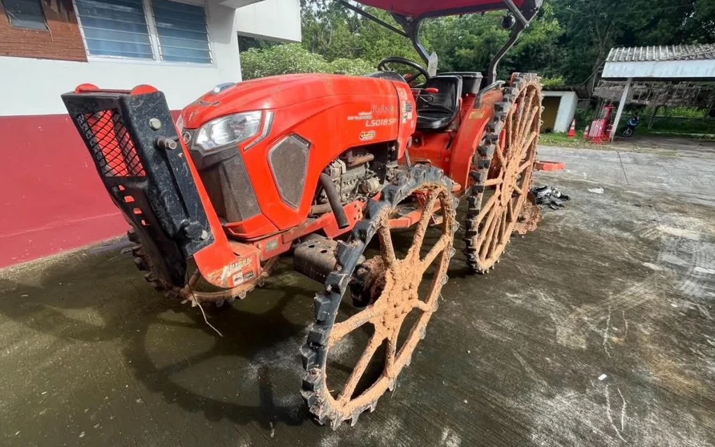 An orange Kubota tractor parked on a concrete surface.