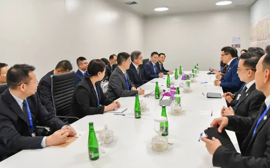 Akaniti Nitithanprapas and officials in a formal meeting in Hong Kong.