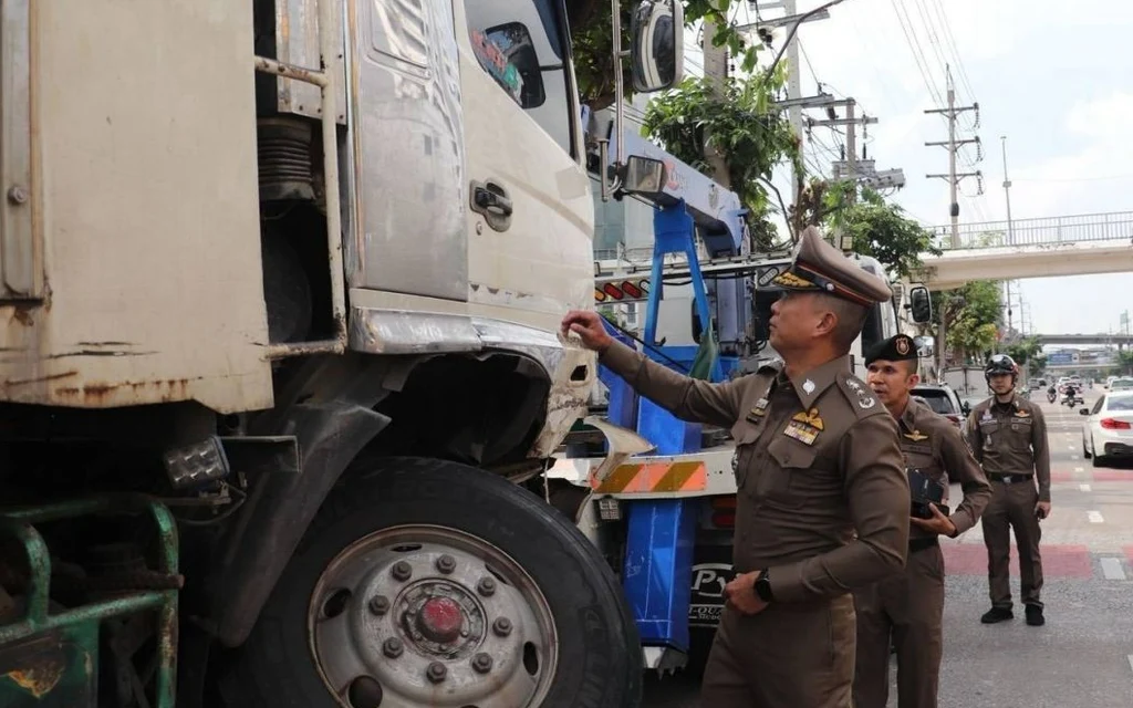 Police officers inspect a damaged truck involved in a multi-vehicle crash.