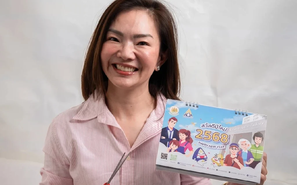 A woman holding a 2025 calendar and scissors.