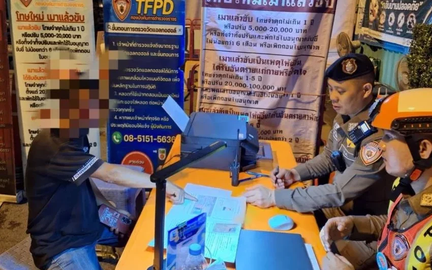 Police officer at a desk checking documents with a blurred person