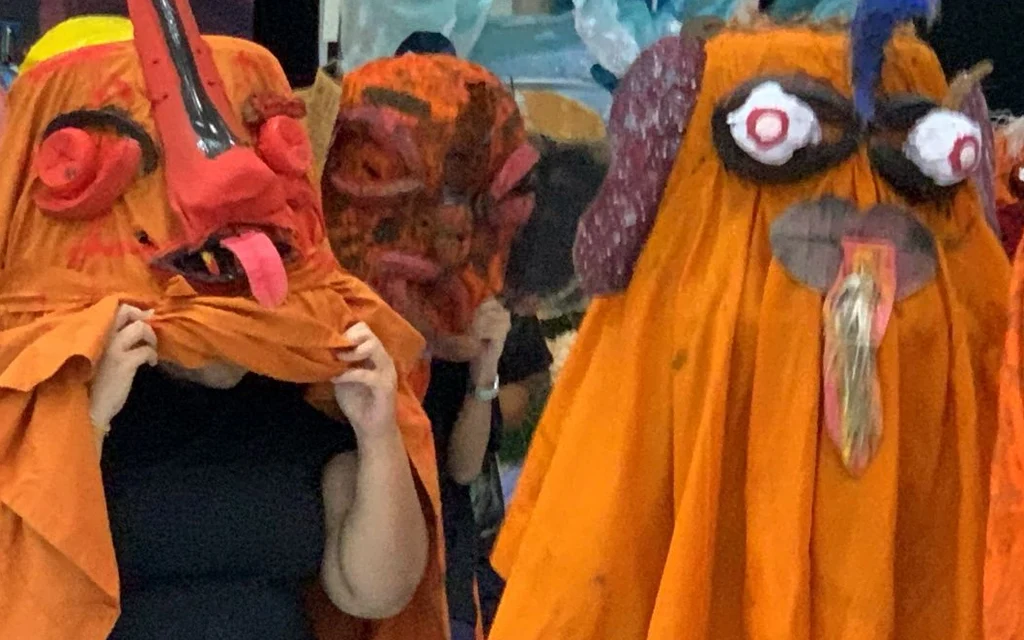 People wearing colorful ghost costumes for a parade.