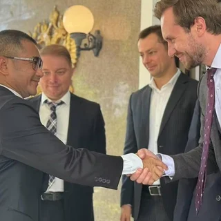Thai police official shaking hands with a Russian diplomat.