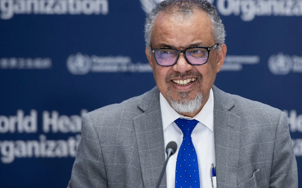 WHO official speaking at a press conference against a World Health Organization backdrop