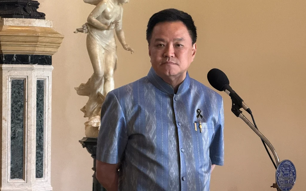 Anutin stands beside a microphone in a formal indoor setting.