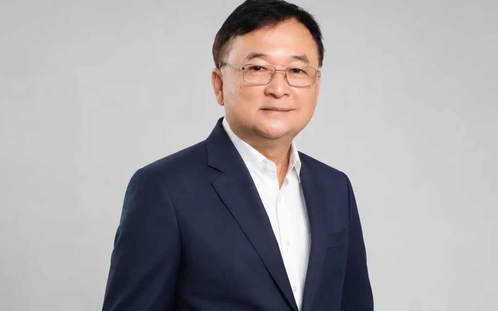 A portrait of a middle-aged man wearing a suit and glasses.