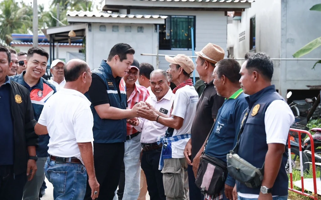 Officials greet residents during a visit to a neighborhood.