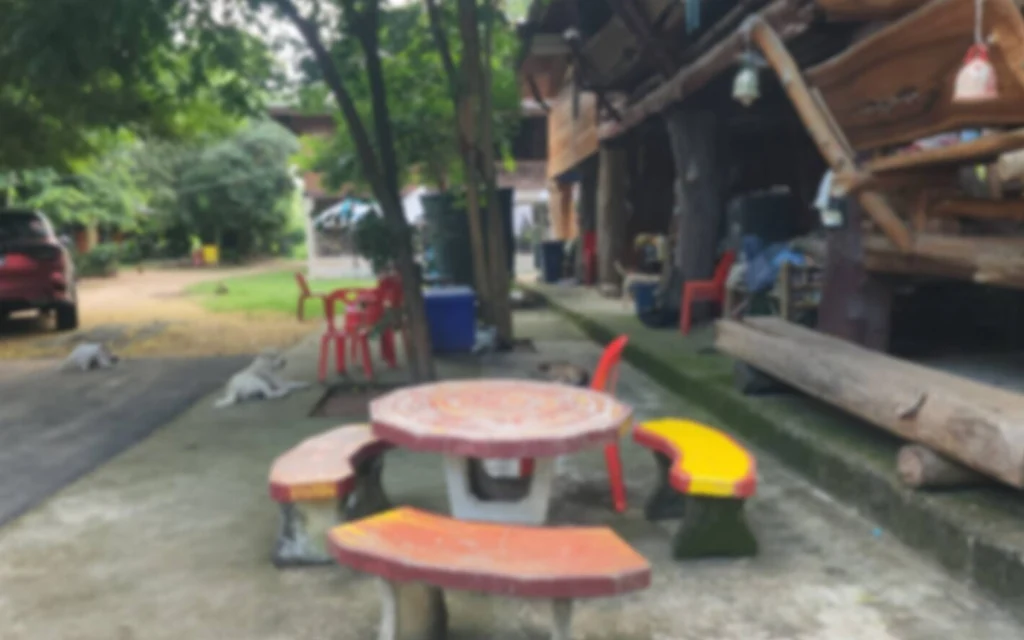 Outdoor area with colorful concrete tables and benches near a wooden building.