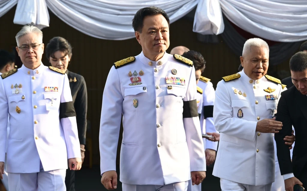 Thai officials in formal white uniforms attend a public event.