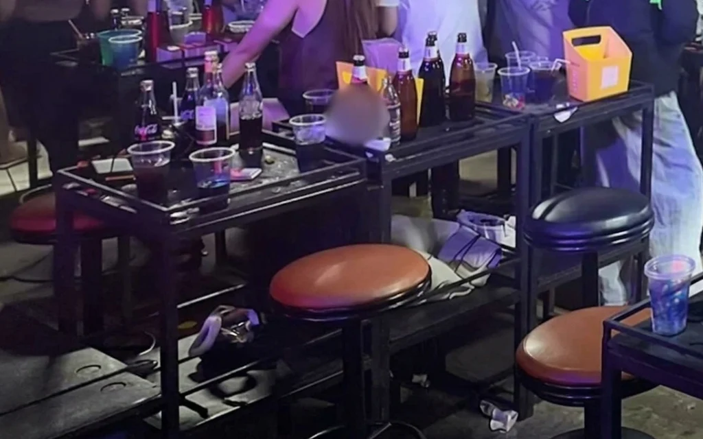 Tables and stools in a nightclub setting with drinks.