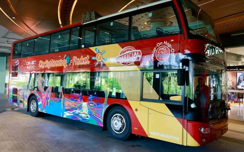 Colorful double-decker tourist bus parked inside a modern building terminal