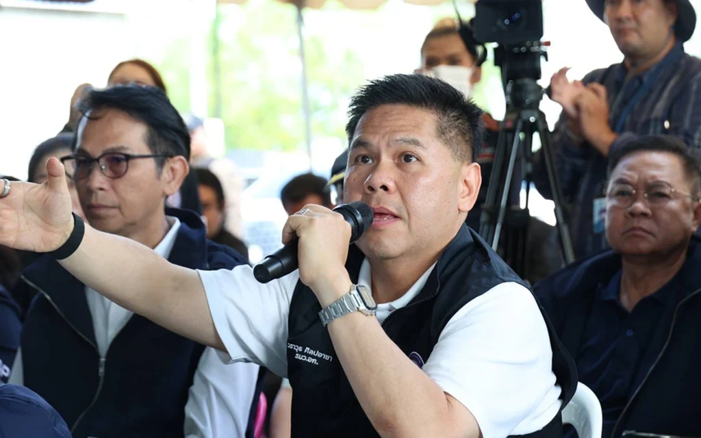 Industry minister speaks into a microphone during a factory visit.