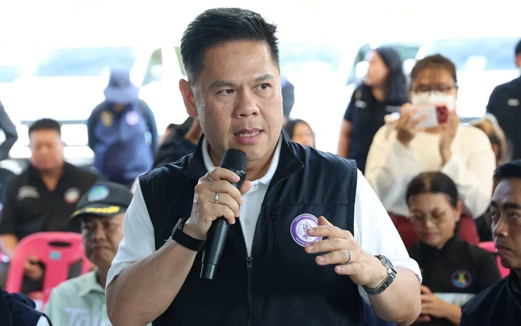 Man speaks into a microphone at a crowded public event.