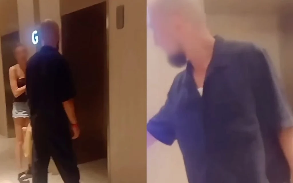 A man and a woman in a hotel hallway.