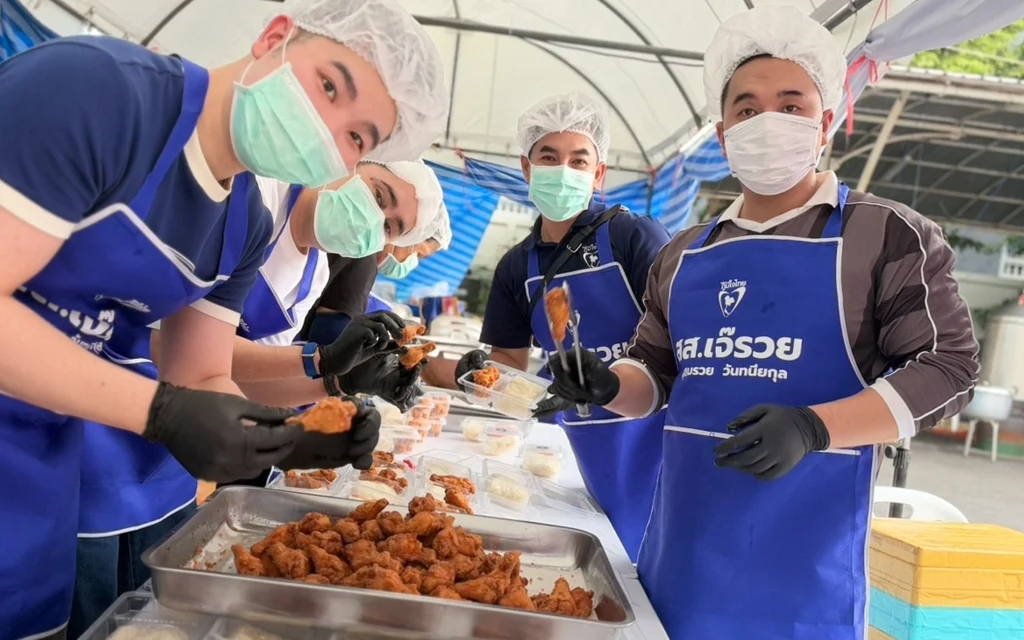 Masked volunteers prepare food at a community kitchen.