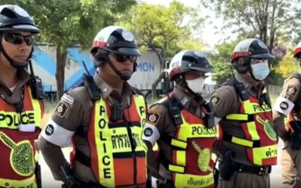 A line of Thai police officers standing in uniform.