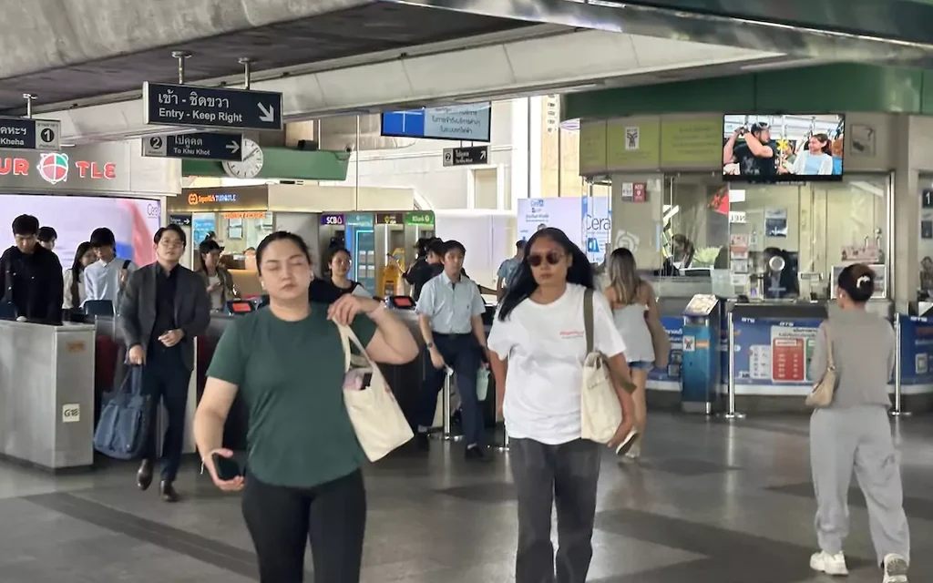 Commuters walking through a Bangkok BTS Skytrain station.