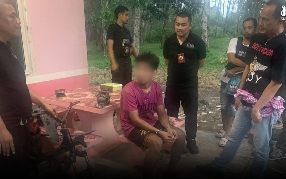 A seated suspect with a blurred face is surrounded by men