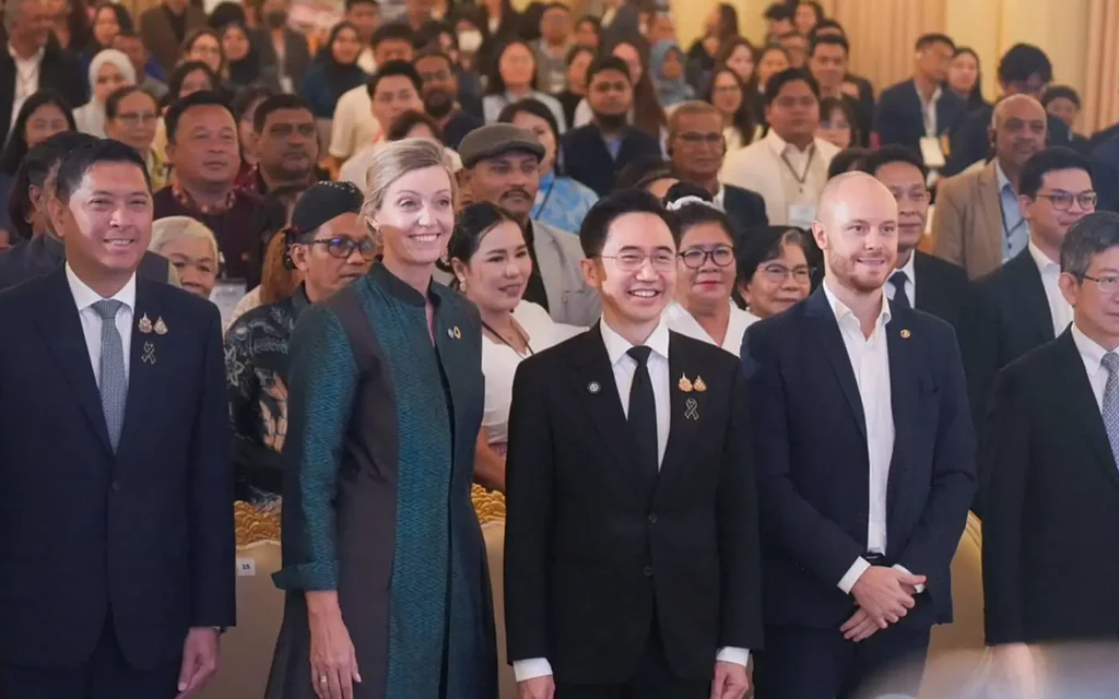 Officials and attendees pose at a crowded international housing award event.