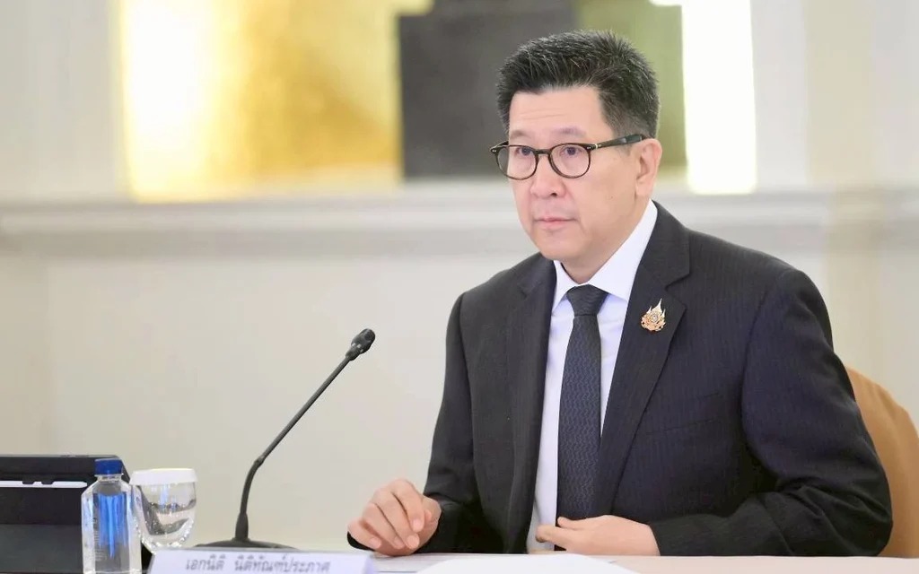 Ekniti Nitithanprapas sitting at a table during a meeting.