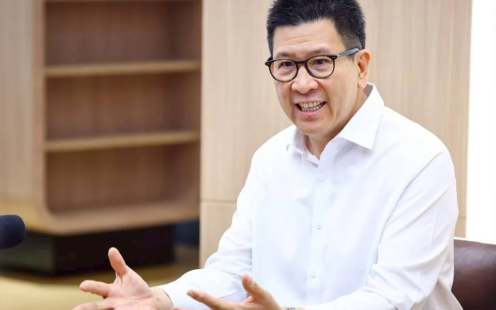 Man in glasses and white shirt speaking in an office