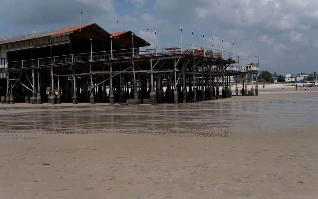 A structure built on stilts over the beach.