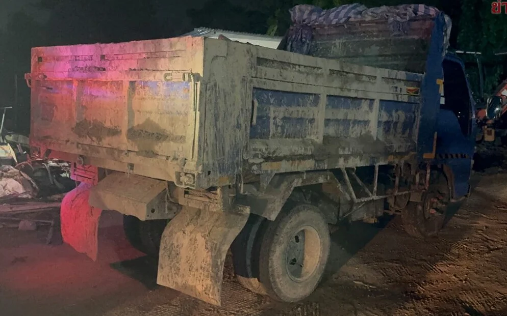 A dump truck parked at night.