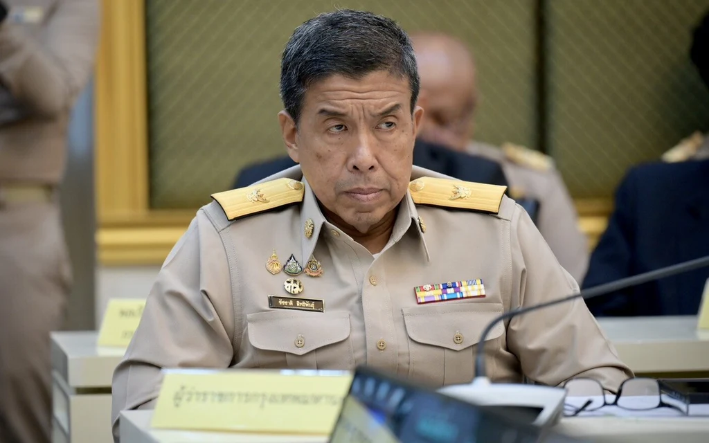 Thai official in uniform seated at a meeting table