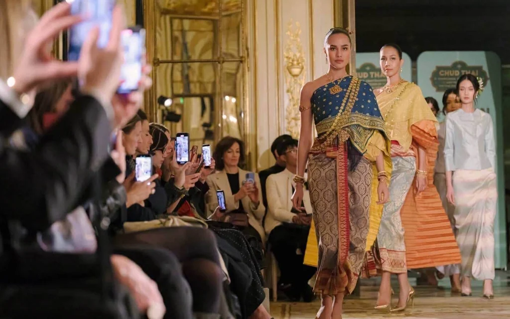 Models wearing traditional Thai costumes on a runway in Paris.