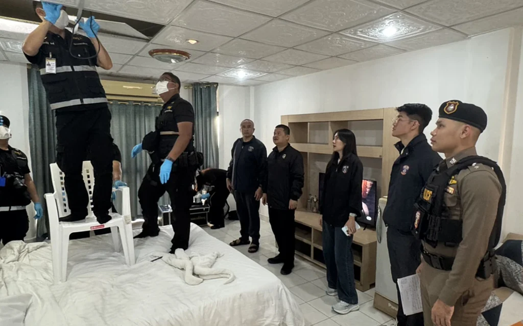 Police inspect equipment in a hotel room during a raid.