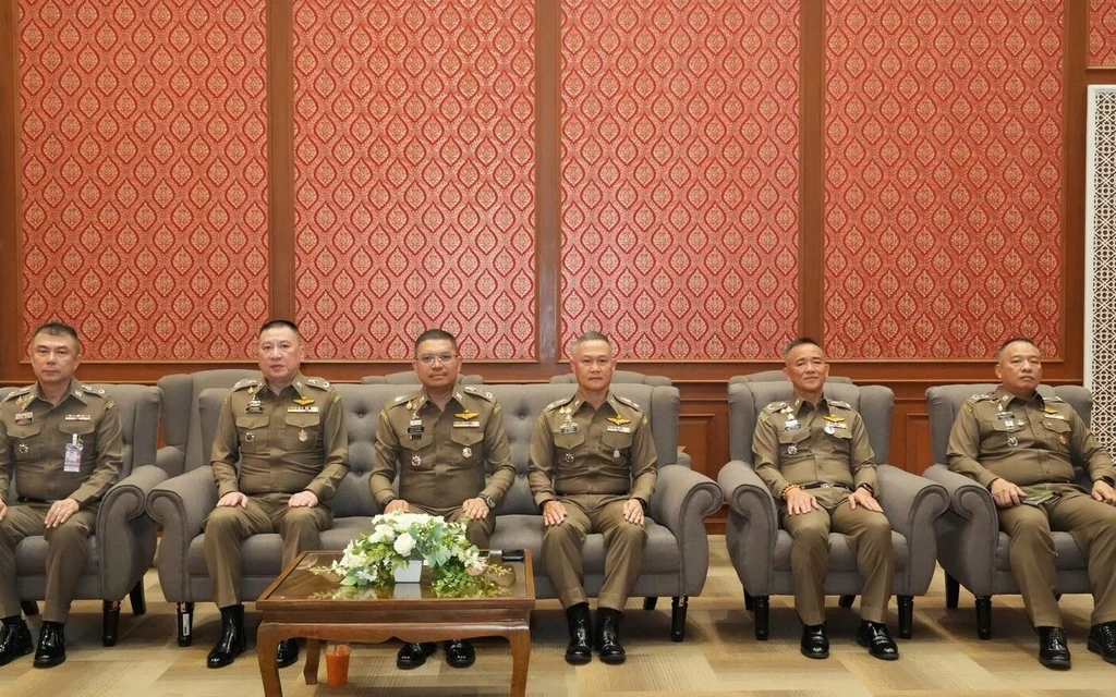 Thai police officers sitting in a row on sofas.