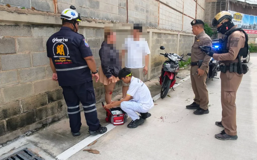 Rescue worker treating an injured person on the ground.