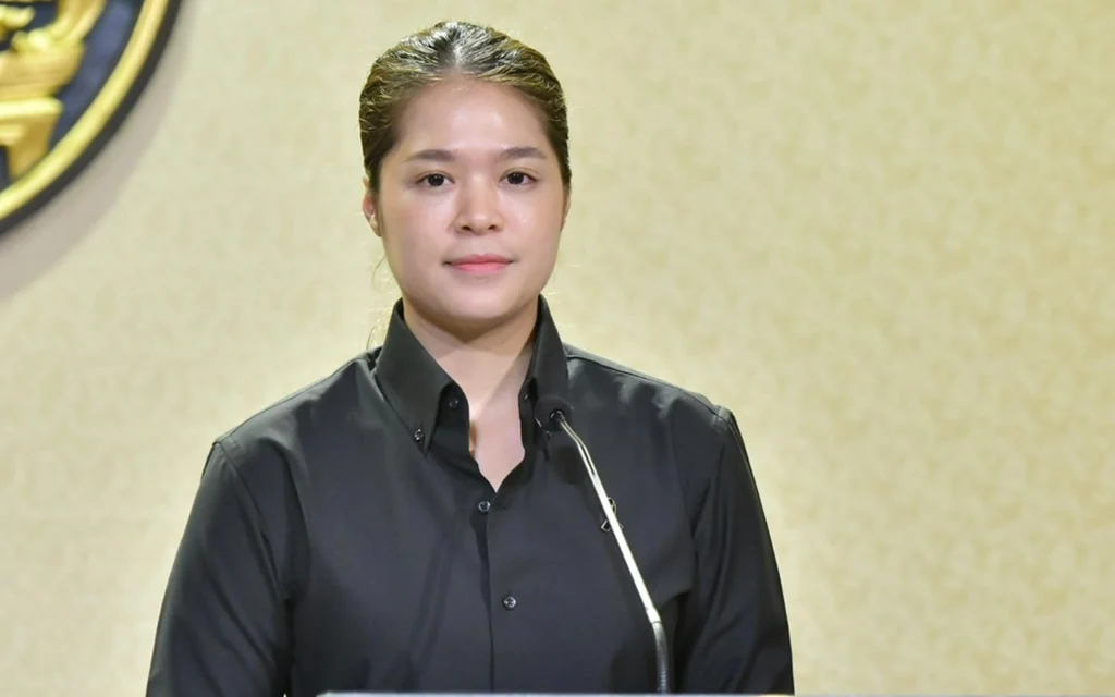 Woman speaking at a podium in front of an official emblem
