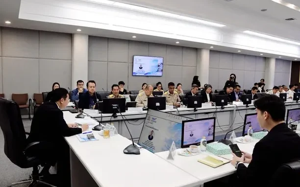Officials and staff attend a meeting in a conference room.