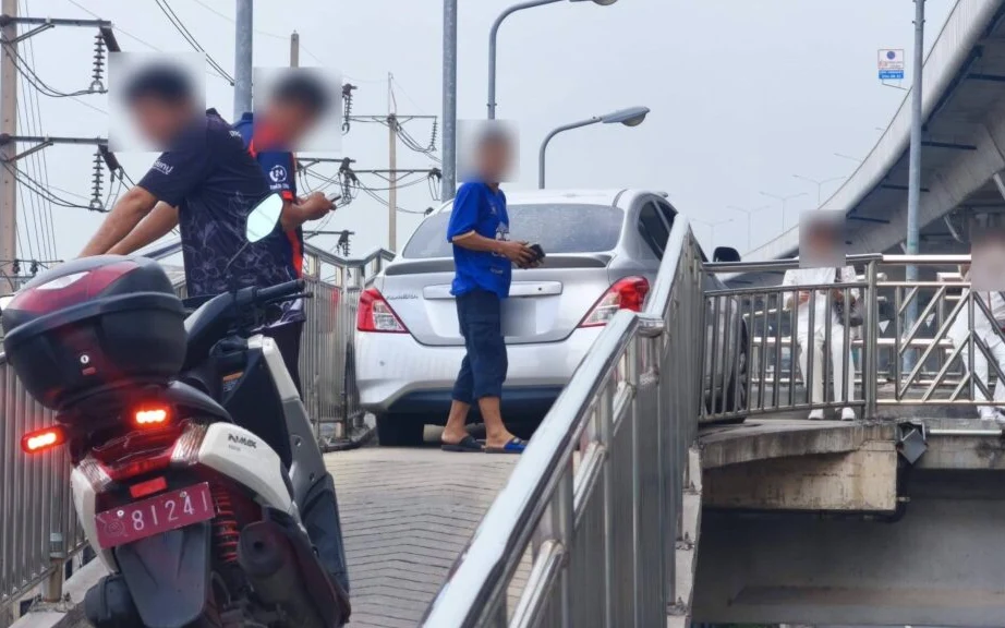 A car stuck on a narrow motorcycle bridge in Samut Sakhon.