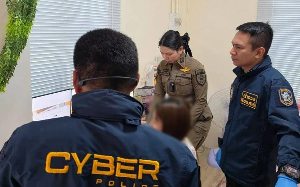 Cyber police officers inspect a computer during a gambling investigation.