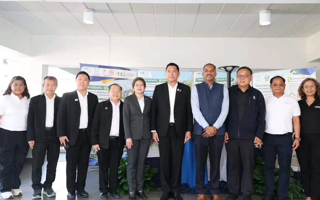 Group of officials and attendees posing at an indoor event