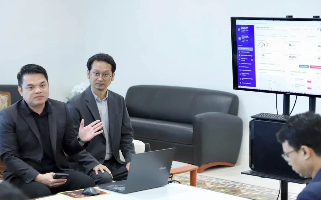 Officials discuss an AI tourism safety system in an office.
