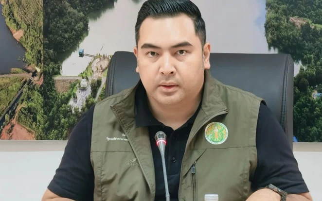 A deputy minister speaks at a desk with a microphone.