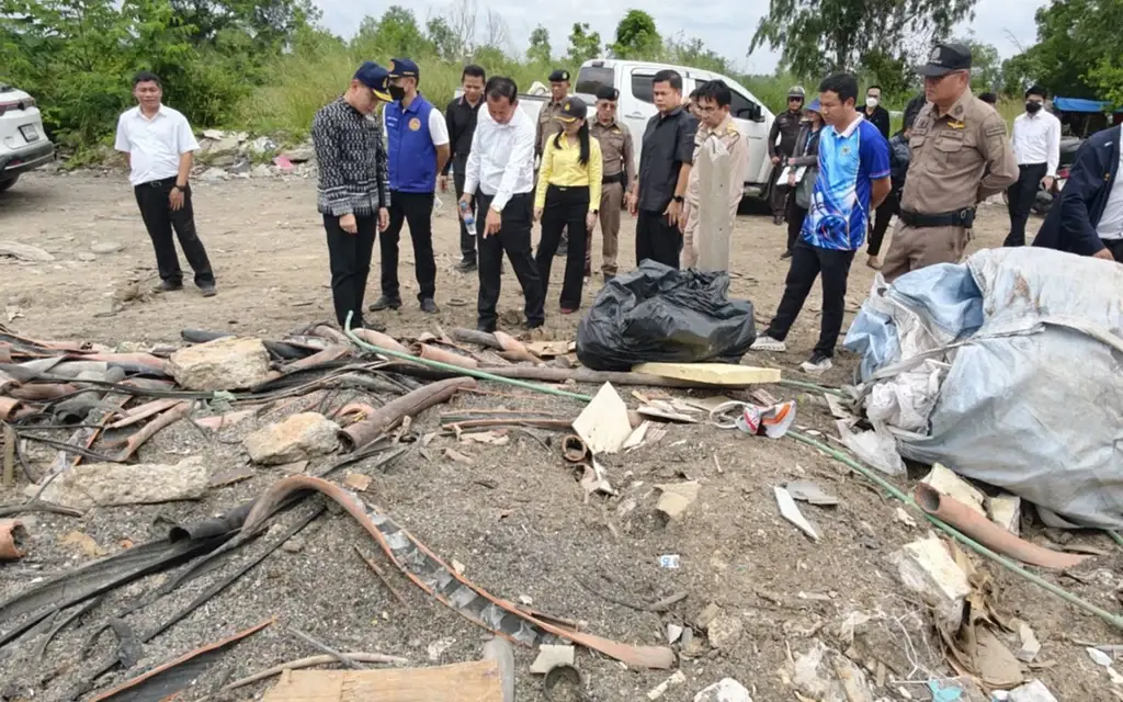 Officials inspect debris and discarded materials at an illegal waste dump.