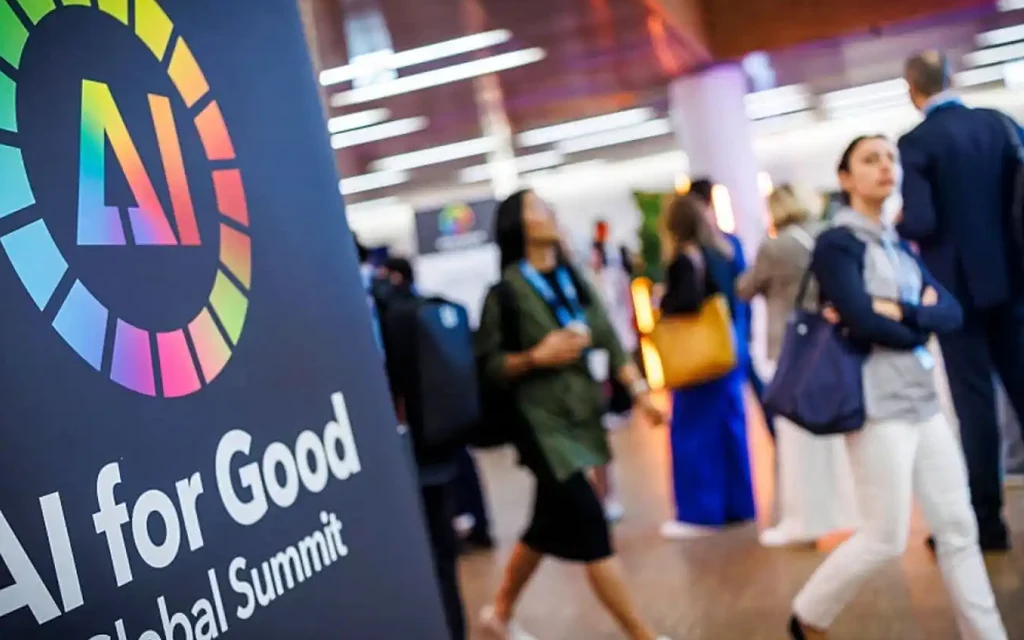 People walking past an AI for Good Global Summit sign.