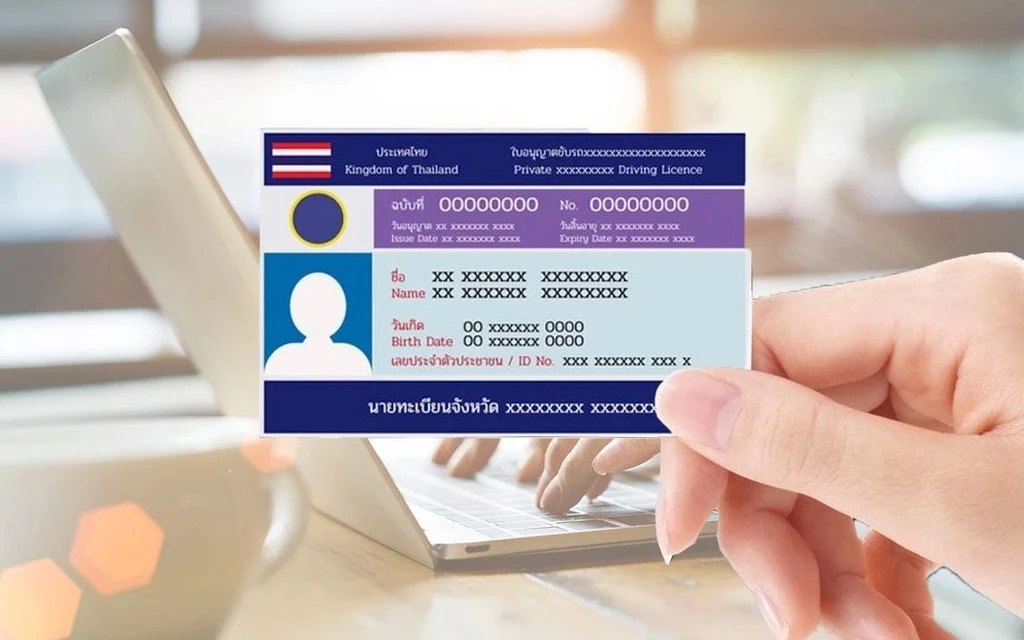 A hand holding a sample Thai driving license card